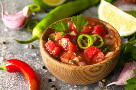 Traditional Latin American mexican salsa sauce with ingredients on a light stone table.の写真素材