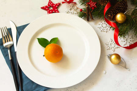 New Year, Christmas dinner, table setting. Christmas table with plate, silver and Fir branch on a white concrete table.の写真素材