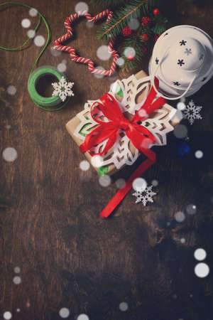 Christmas background. Xmas gift box, branch of a Christmas tree and decorations on rustic background with light bokeh effect. Top view flat lay background.の写真素材