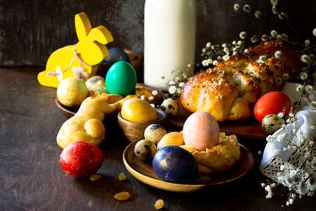 Easter holiday table. Easter cakes and colored eggs on a wooden table.の写真素材