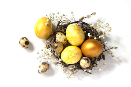 Decorative yellow easter eggs in a nest on a white background.