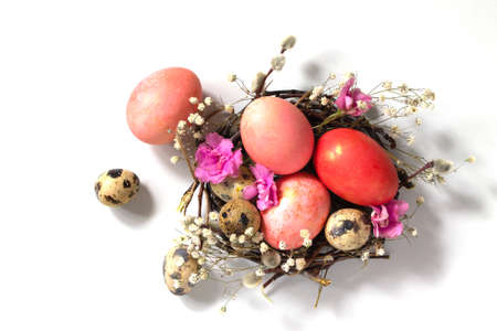 Decorative pink easter eggs in a nest on a white background.