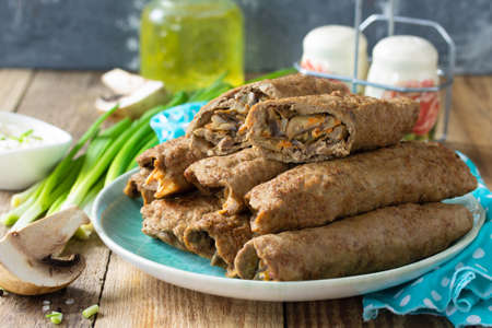 The concept of a healthy breakfast or snack. Meat liver pancakes stuffed with mushrooms and...