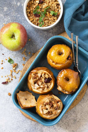 Diet menu. Healthy dessert. Baked apples with walnuts, honey and granola on slate, stone or concrete background. Top view flat lay background.の写真素材