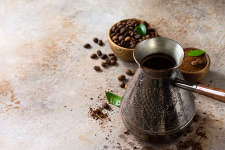 Morning coffee concept. Turkish coffee in Turk and coffee beans on a stone or slate countertop. Copy space.の写真素材