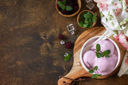 Homemade Organic Ice Cream with Mint. Blackberry ice cream in white bowl on a rustic table. Top view flat lay background. Copy space.の写真素材