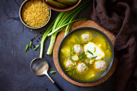 The concept of healthy and diet food. Russian or Ukrainian cuisine. Soup with meatballs, bulgur and...