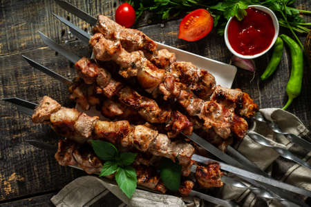 Summer Barbecue menu. Grilled meat skewers on rustic wooden table. Top view flat lay background.の写真素材