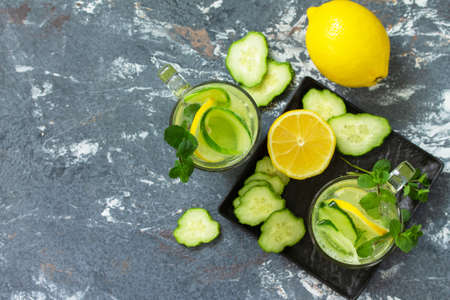 Fresh Cold and refreshing detox water with lemon and cucumber on a stone table. Top view flat lay background. Copy space.の写真素材