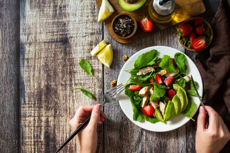 Lunch for keto. Summer salad with strawberries, grilled chicken and avocado on a rustic table. Top view flat lay background. Copy space.の写真素材