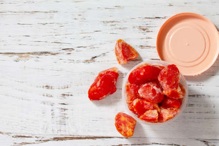 Healthy food is frozen food for the winter. Containers with frozen tomatoes. Top view flat lay background. Copy space.の写真素材