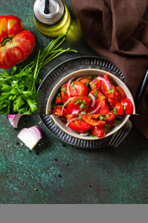 Summer Vegetable salad with fresh tomato, onion and olive oil. Healthy food. Top view flat lay. Copy space.の写真素材