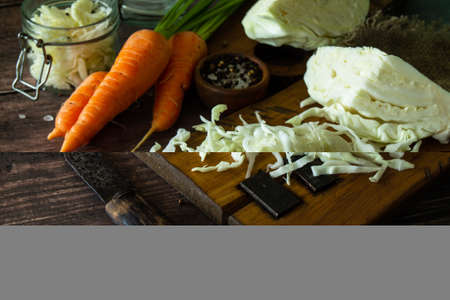 Sauerkraut preserving background. Homemade sauerkraut with black pepper carrot on rustic wooden...
