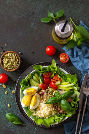Healthy food. Tuna salad with egg, lettuce, quinoa, vegetables and pumpkin seeds. Top view flat lay background. Copy space.の写真素材
