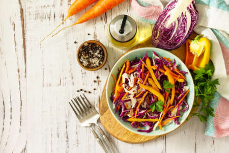 Cole Slaw. Cabbage salad in a bowl on a wooden table. Top view flat lay background. Copy space.