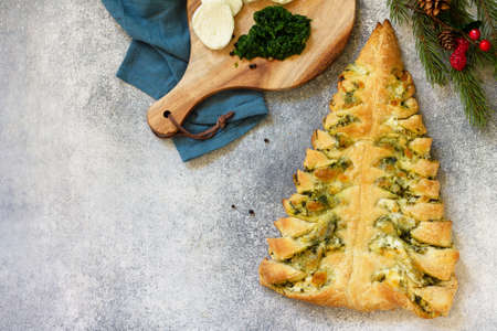 Christmas snack. Pizza with mozzarella and spinach on a gray tabletop background. Copy space.