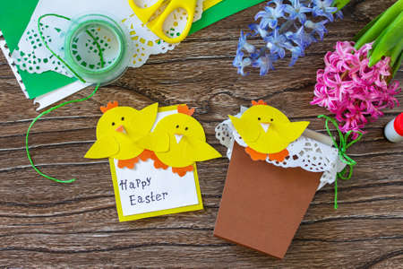 Child gift postcard happy easter chickens toy on a wooden table. Handmade. Project of childrens...