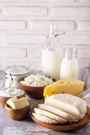Set of different dairy products (milk, sour cream, cottage cheese, yogurt and butter) on a light stone countertop. Copy space.の写真素材