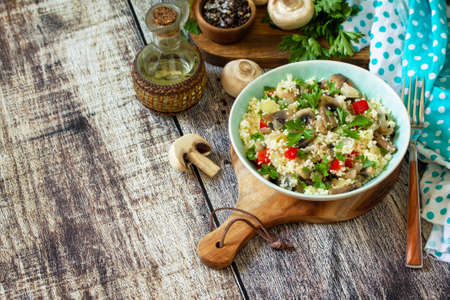 Diet food vegan concept. Vegan salad with couscous and champignons on a wooden table. Copy space.の写真素材