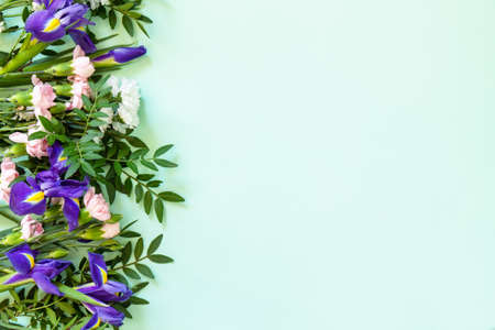 Mother's day or birthday background. Spring beautiful bouquet of blooming carnations and irises and...