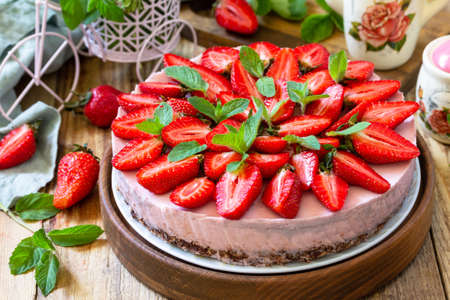 Summer diet dessert without baking Gluten-free, birthday menus. Strawberry cheesecake on a granola with fresh strawberries on a on rustic wooden table.の写真素材