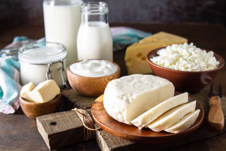 Set of different dairy organic products (milk, sour cream, cottage cheese, yogurt and butter) on a rustic wooden countertop.の写真素材