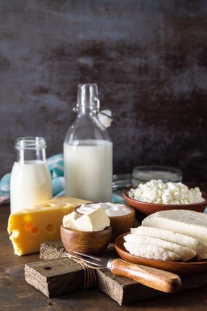 Set of different dairy organic products (milk, sour cream, cottage cheese, yogurt and butter) on a rustic wooden countertop. Copy space.の写真素材