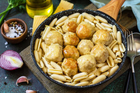 Italian pasta. Spaghetti with meatballs in cheese sauce on a dark stone or concrete background.の写真素材
