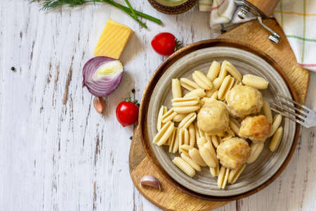 Italian pasta, keto diet lunch. Spaghetti with meatballs in cheese sauce on a wooden table. Top...