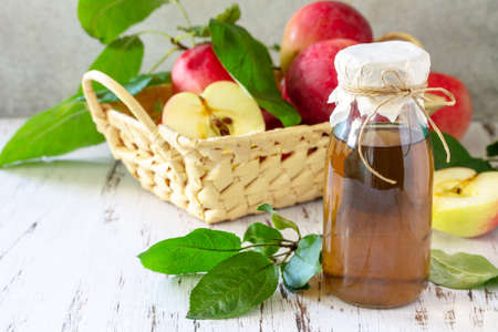 Healthy organic food. Apple vinegar, a bottle of apple cider vinegar on a rustic table.