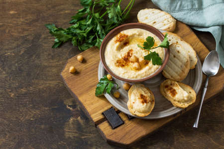 Middle Eastern, Hummus Arabic Cuisine. Vegetarian dips Homemade chickpea hummus with olive oil, paprika on a rustic table. Copy space.の写真素材