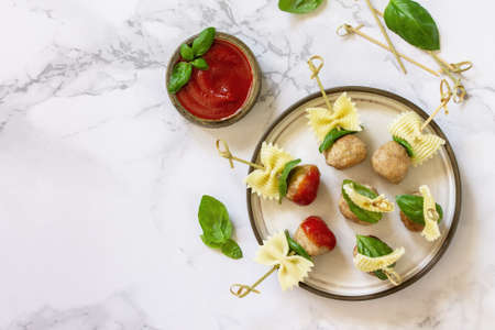Birthday or romantic dinner. Pasta cooked in the form of canapes, meatballs, served with tomato sauce on a marble countertop. Top view flat lay. Copy space.の写真素材