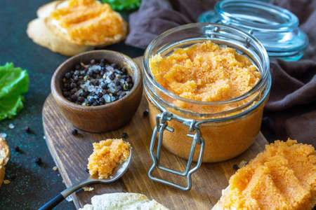 Sandwiches with butter and salted caviar on a dark stone countertop.の写真素材