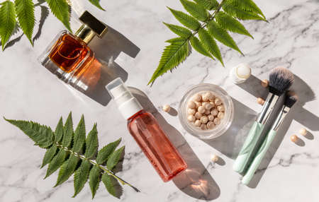 Makeup flat lay. Professional makeup. Brushes, perfume and other decorative cosmetics on marble countertop.の写真素材