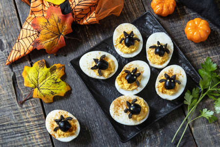 Halloween funny idea for party food. Halloween creative set stuffed eggs with paprica and bat on a...