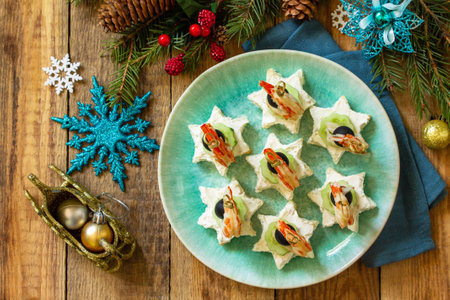 Festive snack of canapes on the Christmas table. Canapes with cheese, cucumber and shrimps. Top view flat lay background.の写真素材