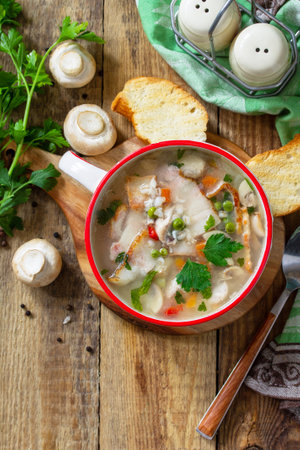 Traditional rustic thick german pea soup with smoked bacon, mushrooms and cereals on wooden table. Hot dinner or lunch. Top view flat lay. Copy space.の写真素材