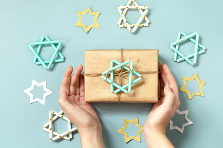 Jewish holiday Hanukkah. A gift and symbol of Hanukkah star of David on a blue background. Top view...