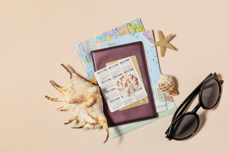 Minimal summer travel vacation concept. Passport with map, passport, starfish, glasses, bank card on sand color background. Flat lay.の写真素材