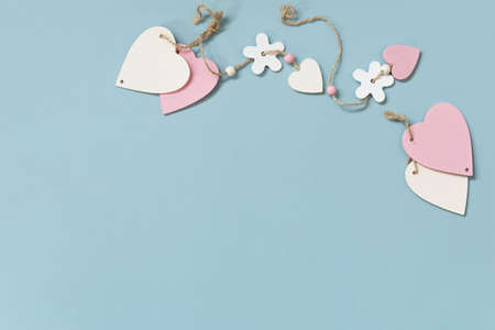Valentine's day concept with heart decor on a blue background, minimal layout. Top view flat lay with copy space.の写真素材
