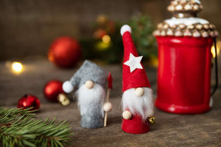 Holiday Xmas concept. Christmas card with gnomes, fir tree, christmas lights and decor on a rustic wooden background.の写真素材