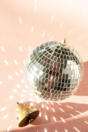 Minimal creative. Christmas decorations and mirror disco balls on sand color background. Party time, Greeting card.の写真素材