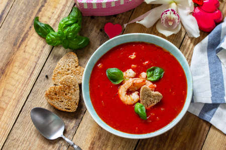 Homemade Valentine soup, festive food. Tomato soup puree gazpacho with tomatoes served seafood on a rustic wooden table. Copy space.の写真素材