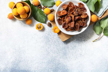 Dried fruits. Dried apricots and raw apricots on a gray stone background. view from above. copyspace.の写真素材