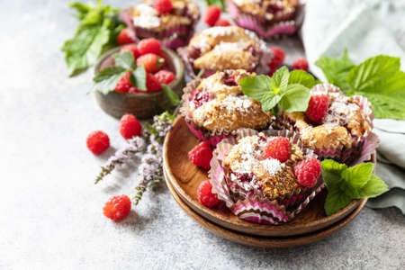 Healthy dessert. Vegan gluten-free pastry. Oatmeal banana muffins with raspberry and coconut flakes on a stone table. copyspace.の写真素材