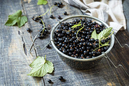 Raw organic berries. The concept of vitamin c food. Fresh black currants on a wooden table in rustic style.の写真素材