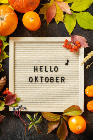Autumn background with Hello October letters and autumn message board, pumpkins and colorful leaves....