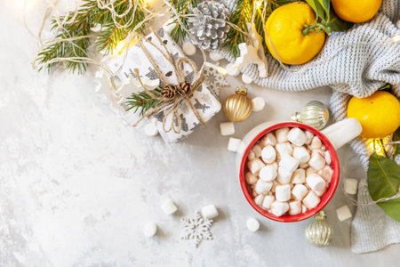 Christmas winter cozy cup with hot chocolate drink with marshmallow and gifts, tangerines on a gray stone background. Christmas food and drink concept. view from above. copyspace.の写真素材