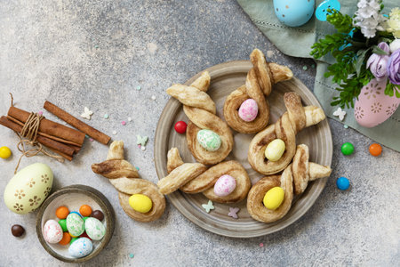 Easter bake ideas. Easter rabbit-shaped buns puff pastry with cinnamon on a stone tabletop. view...