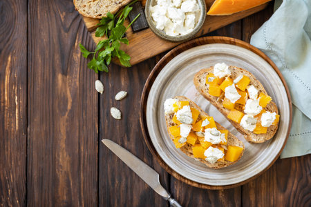 Healthy food, vegetarian appetizer on a rustic table. Open sandwiches whole grain ciabatta with spice pumpkin and feta cheese. view from above. copyspace.の写真素材